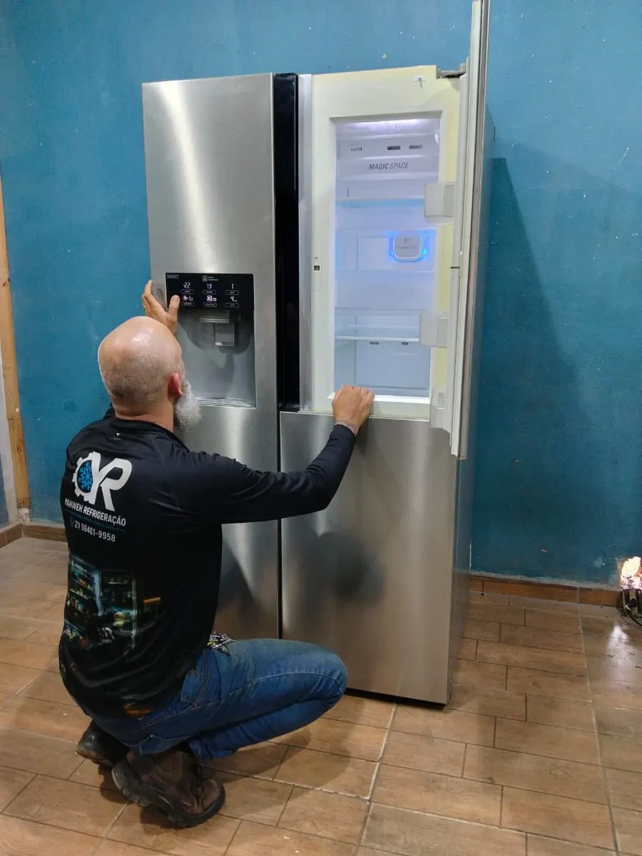 Técnico da Yahweh Refrigeração verificando geladeira side by side LG com dispenser de água
